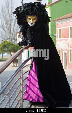 Une femme masquée dans un costume noir au carnaval de Burano, Venise, Italie, Europe Banque D'Images