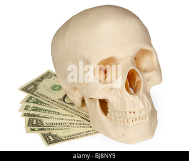 Le crâne humain allongé sur un paquet d'argent isolé sur fond blanc Banque D'Images
