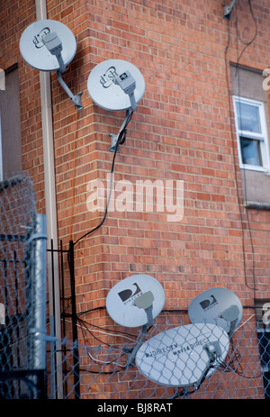 DirecTV et Dish Network des antennes paraboliques sur un immeuble à appartements. Banque D'Images