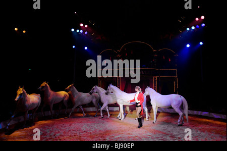 Un entraîneur de chevaux vêtus de rouge, au milieu d'un spectacle dans le ring. Le Cirque Roncalli. Munich, Allemagne Banque D'Images