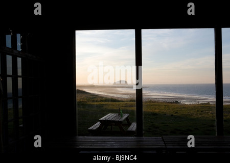 Vue sur la plage et le littoral écossais à travers de grandes fenêtres de maison en bois Banque D'Images