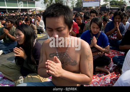 Un jeune homme en prière au cours de Wai Kru Journée à Wat Phra Bang, un temple bouddhiste en Thaïlande où les moines dévots de tatouage. Banque D'Images