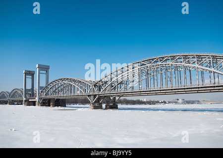 Pont de chemin de fer de l'autre côté de la rivière Neva, Russie, Saint-Pétersbourg. Ciel bleu et l'heure d'hiver Banque D'Images