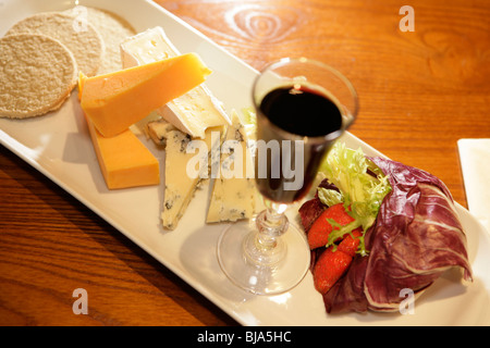 Verre de Porto et de sélection de fromages sur assiette blanche Banque D'Images