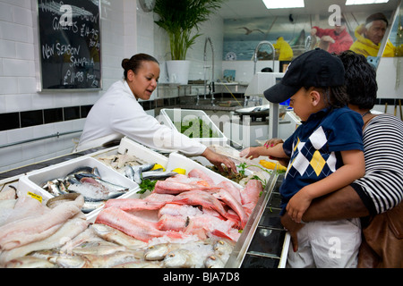 Jeune garçon à la recherche de fruits de mer à la sur l'affichage à l'poissonnier local Banque D'Images