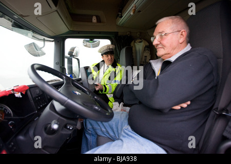 Un agent de police parlant à un conducteur de camion dans son taxi Banque D'Images