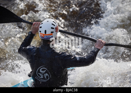 L'équipe galloise kayak Kayakiste en kayak en eau vive sur la rivière Tryweryn au niveau national Whitewater Center, au nord du Pays de Galles, Royaume-Uni. Banque D'Images