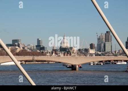 Vue vers l'est le long de la Tamise à Londres, vers la Cathédrale St Paul de Hungerford, pont de Charing Cross, Londres, Royaume-Uni. Banque D'Images