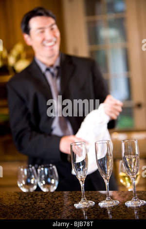 Bouteille de champagne ouverture homme asiatique, verres vides à Banque D'Images