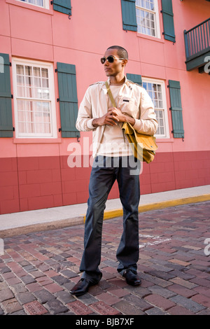 Beau jeune homme élégant afro-américaine tenue sac dans Street Banque D'Images