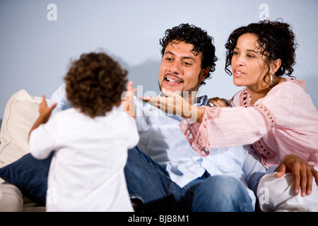 Young Hispanic family avec fils âgé d'un an à la maison dans la salle de séjour Banque D'Images