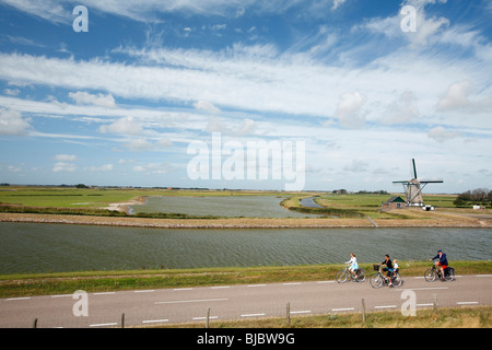 Les touristes à vélo passé, moulin à vent traditionnel de Moll - Oost, île de Texel, Hollande Banque D'Images