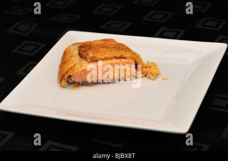 Saumon en croute sur une assiette blanche sur noir table cloth Banque D'Images
