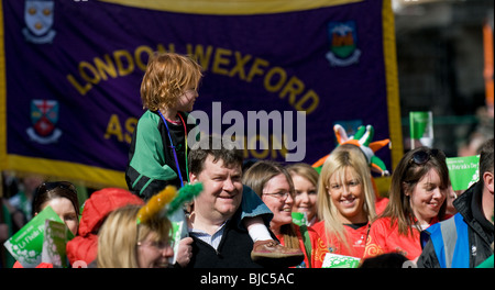 Une femme enfant assis sur son père pendant l'sholuders St Patricks Day Parade à Londres. Banque D'Images