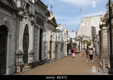 Les touristes à pied le long de la rangée d'anciens mausolées dans une rue de recoleta cemetery Capital Federal Buenos Aires Argentine Banque D'Images