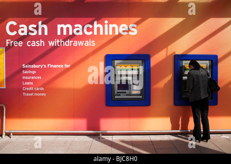 Une paire de trou dans le mur des distributeurs automatiques à l'extérieur du magasin Sainsbury's, Braehead, Renfrewshire, en Écosse. Banque D'Images