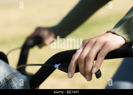 Woman riding bicycle, cropped view