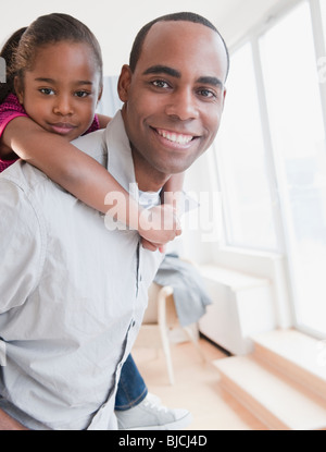 African American father carrying daughter on retour Banque D'Images