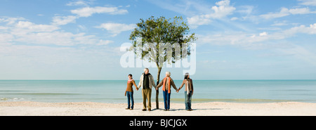 Ecology concept, groupe de gens debout en face d'arbre, holding hands Banque D'Images