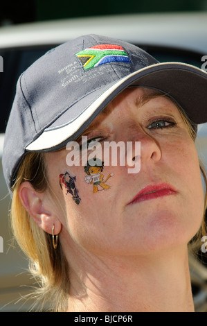 Portrait d'une femme portant un chapeau d'Afrique du Sud et le port de la Coupe du Monde 2010 tatouages sur son visage Banque D'Images