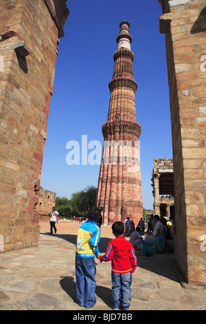 Regarder les garçons par Qutb Minar construit en 1311 passage de la tour de grès rouge ; Indo-Muslim ; art ; sultanat de Delhi Delhi, Inde Banque D'Images