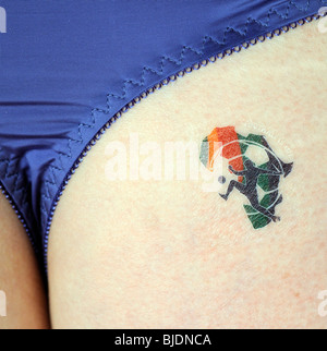 Partisan de soccer féminin portant sur sa fesse une 'Le football est la Vie' tattoo de la Coupe du Monde 2010 Afrique du Sud Banque D'Images