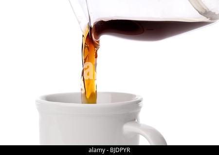 Close up de café est versé dans une tasse de café qu'on white Banque D'Images
