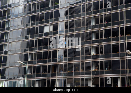 L'homme à l'aide de rappel des cordes pour nettoyer les vitres d'un immeuble de bureaux dans le quartier financier de microcenter capital federal buenos aires Banque D'Images