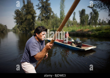 Un homme utilise un bateau à travers le canal de San Gregorio Atlapulco village de Xochimilco, au sud de Mexico City Banque D'Images