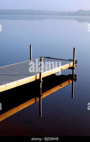 Un seul quai de brume matinale reflète une image en miroir dans le nord du lac WIFI crée une vue magique sur l'horizon lointain Banque D'Images