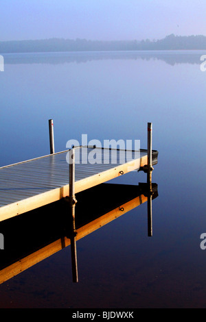 Un seul quai de brume matinale reflète une image en miroir dans le nord du lac WIFI crée une vue magique sur l'horizon lointain Banque D'Images