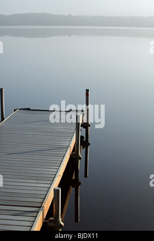 Un seul quai de brume matinale reflète une image en miroir dans le nord du lac WIFI crée une vue magique sur l'horizon lointain Banque D'Images