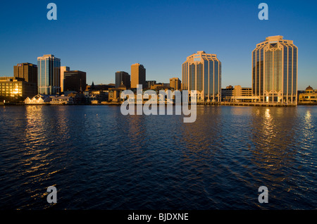 L'horizon de Halifax (Nouvelle-Écosse), juste après le lever du soleil. La lumière du soleil réfléchie par de multiples bâtiments scintille sur l'eau. Banque D'Images