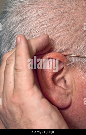 Les droits de l'oreille, écoutant avec cupped hand Banque D'Images