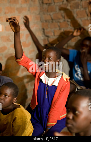 Une fille lève la main dans une salle de classe de Amuria, en Ouganda. Banque D'Images