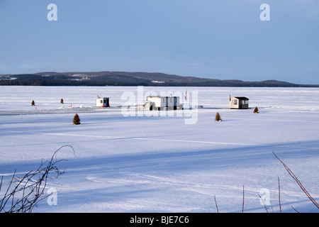 Des cabanes de pêche sur un lac gelé avec la neige en hiver Banque D'Images