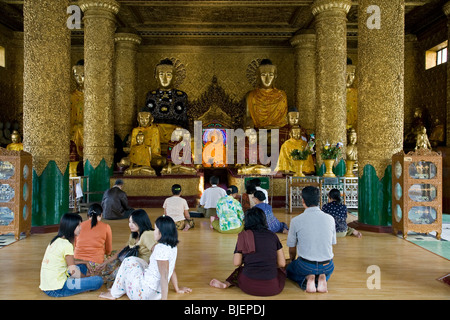 Birmans priant devant les statues de Bouddha. Paya Shwedagon. Yangon. Myanmar Banque D'Images