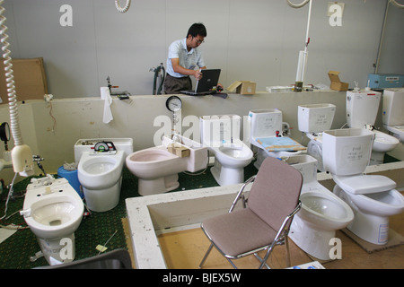 Un employé vérifie les fonctions des différents types d'eau des toilettes, dans les laboratoires de recherche de Toto. Kokura, Japon. 08.08.0 Banque D'Images