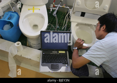 Un employé vérifie les fonctions des différents types d'eau des toilettes, dans les laboratoires de recherche de Toto. Kokura, Japon. 08.08.0 Banque D'Images