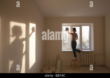 Woman cleaning windows dans nouvel appartement Banque D'Images