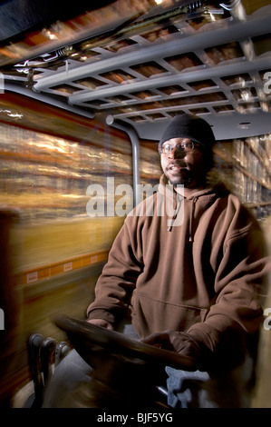 Employé de l'entrepôt sur les chariots des cartons, Philadelphia, USA Banque D'Images