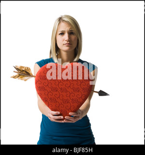 Femme tenant un énorme cœur rouge Banque D'Images