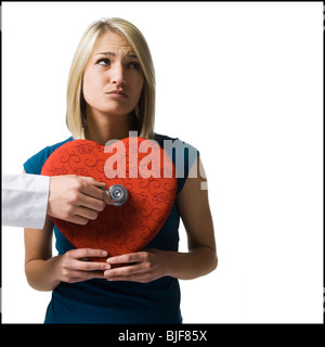 Femme tenant un énorme cœur rouge Banque D'Images