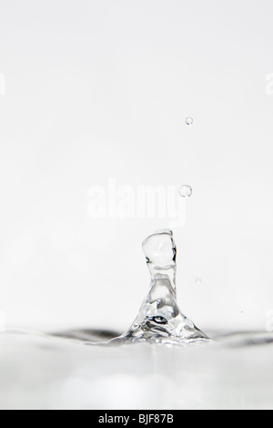 Photographie à haute vitesse d'une goutte d'eau qui rebondissent sur une surface de l'eau. Banque D'Images