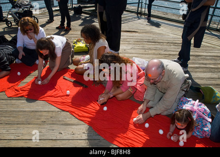 Les participants se réunissent au South Street Seaport de New York d'accueillir l'arrivée du printemps par l'article sur l'extrémité des oeufs crus Banque D'Images