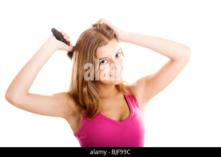 Belle jeune femme peignes cheveux isolé sur fond blanc Banque D'Images