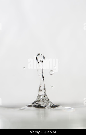 Photographie à haute vitesse d'une goutte d'eau qui rebondissent sur une surface de l'eau. Banque D'Images