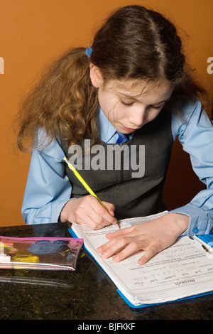 Jeune fille vêtue de l'uniforme scolaire à faire leurs devoirs Banque D'Images