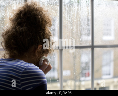 Jeune femme triste/appuyée par la fenêtre des pluies : MODÈLE libéré Banque D'Images