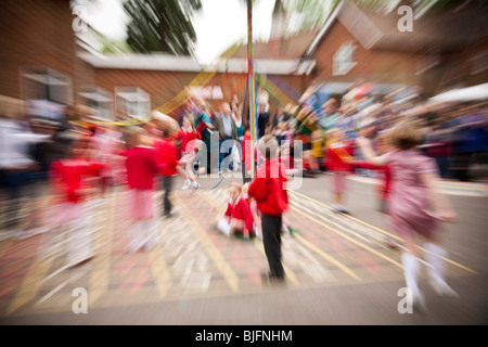 Les enfants de l'école danse autour de l'arbre de mai dans la célébration du premier mai en Angleterre Banque D'Images